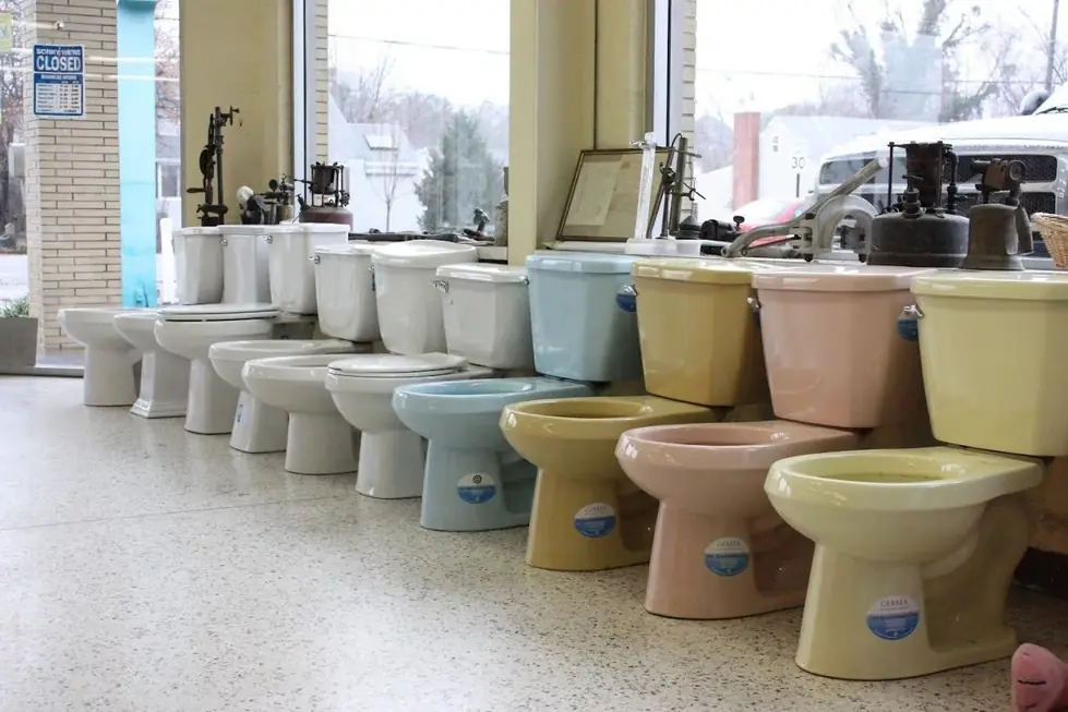 A row of vintage-colour and white toilets on the Ellsworth showroom floor, antique plumbing tools on the window sill