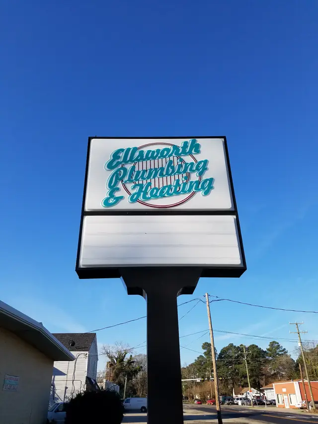 The Ellsworth Plumbing & Heating pole sign against a clear blue sky on Turnpike Road, Portsmouth
