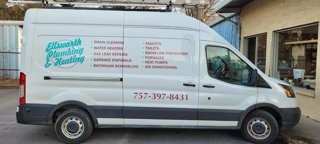 A white Ellsworth Plumbing & Heating Transit van with its service list painted on the side