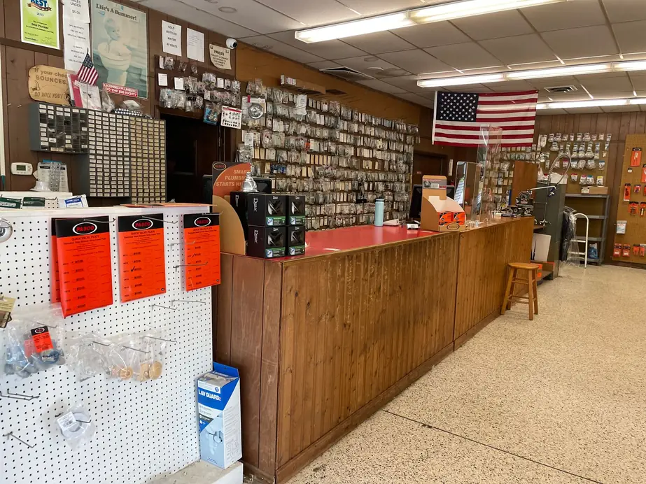 The long wooden parts counter at Ellsworth Plumbing & Heating with pegboard walls of plumbing parts